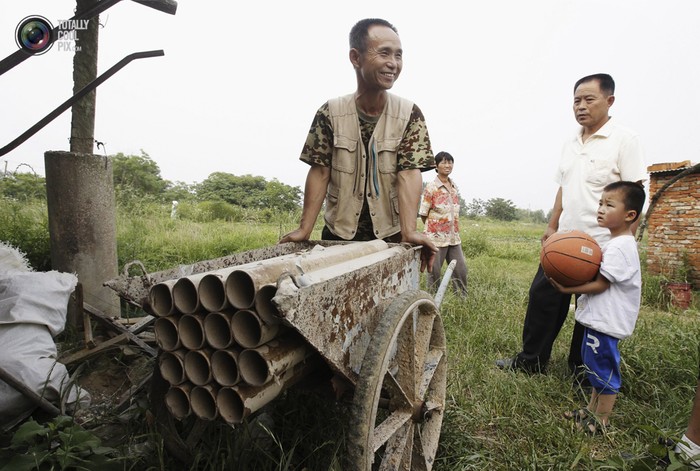 Dương Hữu Đức, một nông dân ở Vũ Hán, tỉnh Hồ Bắc và chiếc súng đại bác có một không hai của mình. Ông đã chế tạo trên chiếc xe cút kít, dùng để đối phó với lực lượng cưỡng chế giải phóng mặt bằng khi gia đình ông chưa đồng ý phương án đền bù.