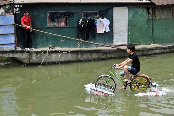 Một thanh niên Vũ Hán chế ra chiếc "xe đạp lội nước" đi trên sông Hán Giang, một nhánh của sông Dương Tử tại Vũ Hán, tỉnh Hồ Bắc.