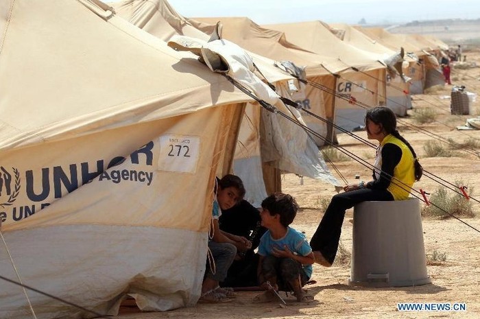Những đứa trẻ bên cạnh khu lều trại do Cao ủy Liên Hợp Quốc về người tị nạn (UNHCR) dựng lên.