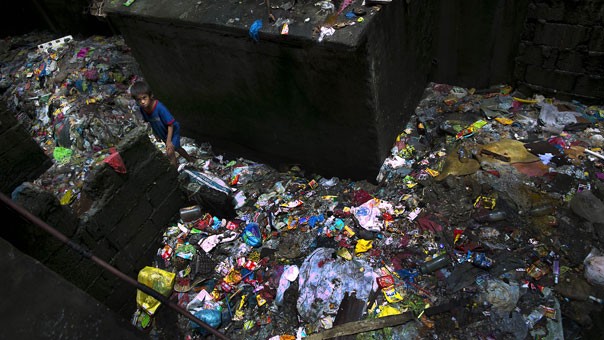 Một cậu bé đang tìm kiếm các loại rác tái chế trong bãi rác ở khu ổ chuột Tondo.