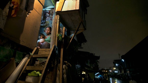 Một phụ nữ và cô con gái nhỏ của mình trong căn lều tạm bợ của họ ở khu ổ chuột Binondo. Họ phải trả 24 USD tiền thuê chỗ ở trong một tháng.