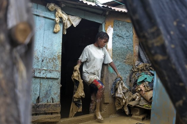 Một người phụ nữ đang dọn dẹp bùn đất sau cơn bão ở thủ đô của Haiti, Port-au-Prince. Isaac đã khiến 6 người thiệt mạng ở Haiti, nơi vẫn đang khắc phục hậu quả của trận động đất năm 2010 và ít nhất 3 người mất tích ở Dominica.