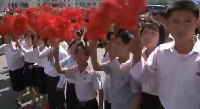 Các học sinh thành phố Bình Nhưỡng vẫy cao những bó hoa chào đón các đại biểu trẻ tuổi.
