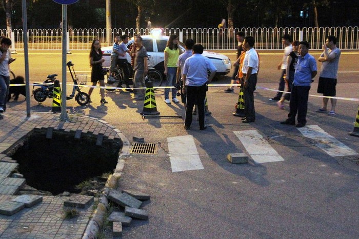 Hố sâu 3m trên đường Bắc Hòa Bình Lý, Bắc Kinh ngày 8/8 khiến một người bị rơi xuống đó nhưng may mắn đã được cứu thoát.