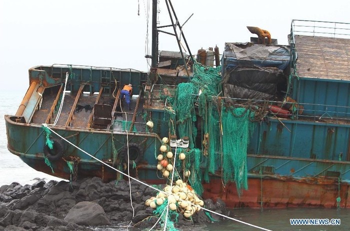 Một nhân viên Hàn Quốc đang làm việc trên chiếc tàu cá đã bị tàn phá nặng nề.