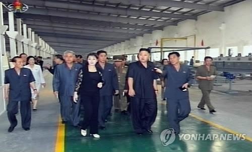 Luôn đi bên cạnh ở một khoảng cách nhất định là Đệ phu nhân của nhà lãnh đạo Kim Jong-un. Bà đã tạo ra nhiều ngạc nhiên khi lần đầu tiên xuất hiện trước công chúng trong một bộ quần áo màu đen, thay vì những chiếc váy như trước đây.