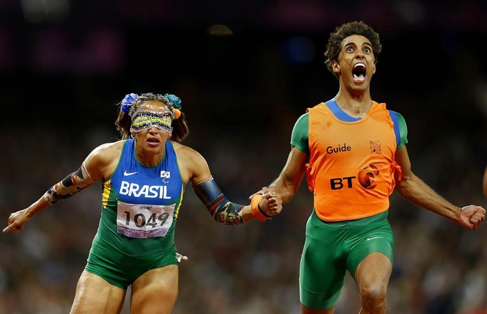 Vận động viên bị mù Terezinha Guilhermina (trái) và huấn luyện viên Guilherme Soares de Santana trong vòng chung kết thi chạy 100m nữ tại Paralympic Games diễn ra ở London, Anh. Guilhermina đại diện cho Brazil đã giành huy chương vàng với thời gian chạy kỷ lục thế giới là 12,01 giây.