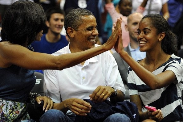 Ông Barack Obama chia sẻ niềm vui với vợ và con gái khi đội tuyển quốc gia Mỹ và Brazil thi đấu trong một trận bóng rổ.