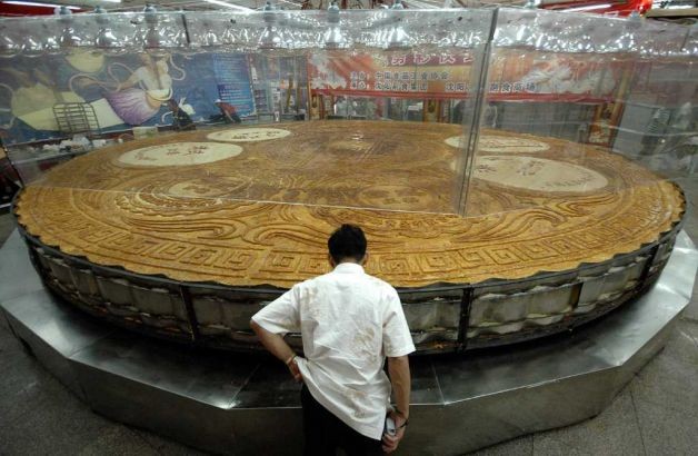 Một đầu bếp kiểm tra chiếc bánh trung thu lớn nhất Trung Quốc mới ra lò tại Thẩm Dương, tỉnh Liêu Ninh vào Tết Trung thu năm 2007. Chiếc bánh này có đường kính 8,15m, độ dày 20 cm, nặng 12,98 tấn và có 10 hương vị. Chiếc bánh đã được làm từ một tấn bột, 12 tấn nhân và nướng trong 10 giờ.