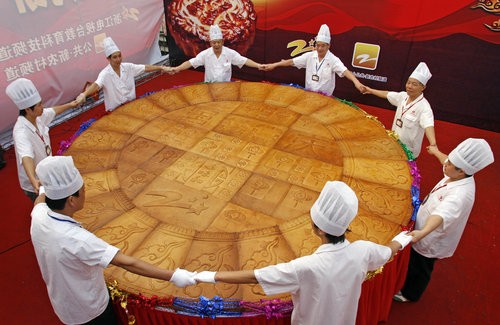8 người thợ bánh mới ôm trọn chiếc bánh trung thu tại Hàng Châu, tỉnh Chiết Giang, ngày 3/10/ 2009.