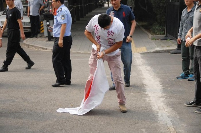 Một người biểu tình Trung Quốc đang xé cờ Nhật Bản.