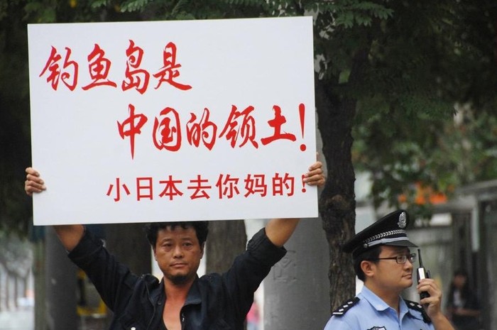 Một người dân giơ tấm biển phản đối Nhật Bản.
