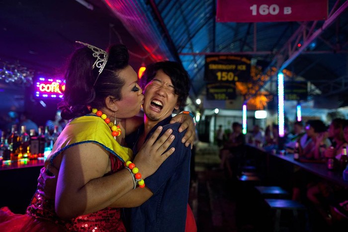 Lily hôn lên má của một khách du lịch Nhật Bản sau khi khi biểu diễn tại Cabaret tại Chiang Mai, Thái Lan. Chương trình Cabaret được thực hiện hàng đêm trong các quán bar nhỏ bên trong chợ đêm của thành phố bận rộn. Những người thuộc giới tính thứ ba rất có thể được thấy và được chấp nhận trong văn hóa Thái