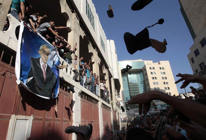 Người biểu tình Palestine ném giày vào tấm ảnh Thủ tướng Salam Fayyad trong một cuộc biểu tình chống lại các chi phí sinh hoạt cao và chính quyền ở thành phố West Bank, Hebron. Thanh niên Palestine đã tấn công một đồn cảnh sát địa phương và các tòa nhà chính phủ khác ở Hebron để phản đối chống lại việc tăng giá cả.