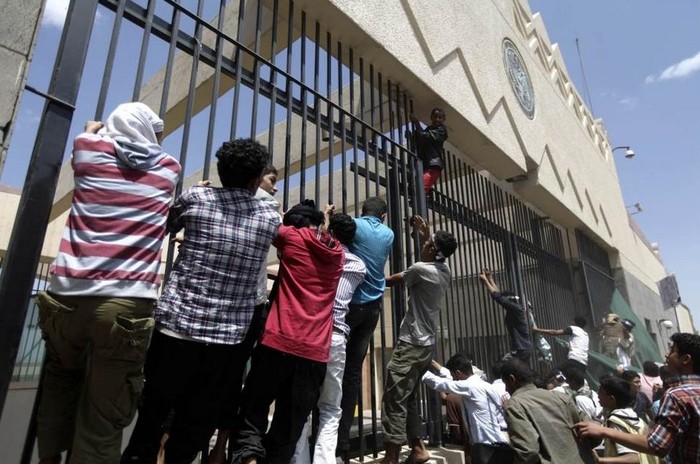 Những người biểu tình cố trèo qua cánh cổng của Đại sứ quán.