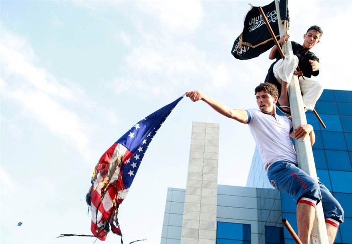 Những người biểu tình đốt cờ Mỹ trong một cuộc biểu tình bên ngoài Đại sứ quán Mỹ ở Tunis. Cảnh sát Tunisia đã bắn hơi cay và đạn cao su vào không khí để giải tán cuộc biểu tình.