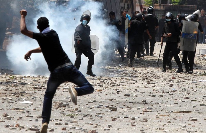 Một người biểu tình Ai Cập ném đá vào cảnh sát chống bạo động trong cuộc biểu tình gần Đại sứ quán Mỹ ở Cairo, Ai Cập.