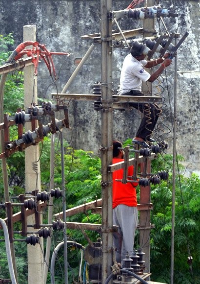 Các công nhân đang sửa chữa dây điện ở thành phố Amritsar. Công ty điện lực đã phải cắt điện vì tình trạng thiếu điện nghiêm trọng.