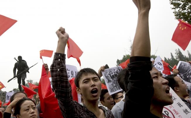Người dân Trung Quốc giơ cờ, biểu ngữ, hô khẩu hiệu phản đối Nhật Bản.