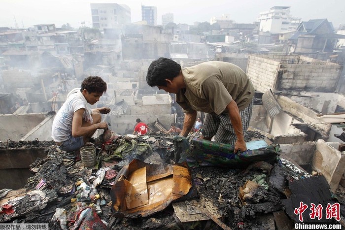 Dọn dẹp đống hoang tàn sau hỏa hoạn - điều đã xảy ra không ít lần ở các khu ổ chuột ở Philippines.