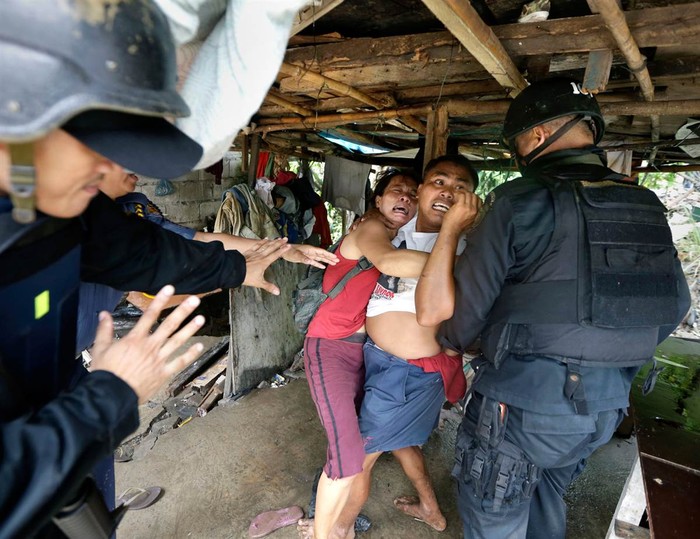 Cảnh sát quốc gia và thành viên đội đặc nhiệm Philippine đang cố gắng bắt giữ những người định cư trong quá trình cưỡng chế giải phóng mặt bằng một khu ổ chuột của họ tại thành phố Taguig, phía đông Manila, để mở đường cho các dự án phát triển mới.