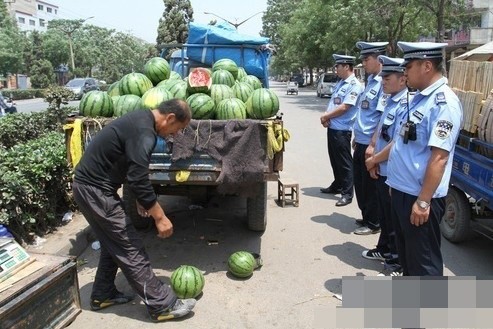 Một người bán dưa hấu đang phải dọn dẹp hàng hoá trước áp lực không lời của dân phòng Trung Quốc.