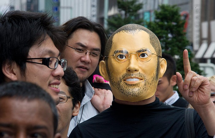 Một khách hàng đeo mặt nạ của người đồng sáng lập Apple Steve Jobs khi xếp hàng để mua chiếc iPhone mới nhất ở Tokyo, Nhật Bản,