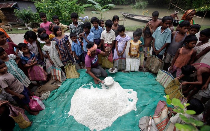 Những đứa trẻ đến nhận viện trợ gạo ở làng Burhabrhi ở Assam. Trận lũ lụt đã khiến cuộc sống vốn đã khó khăn của người dân vùng đông bắc Ấn Độ càng trở nên khó khăn hơn.