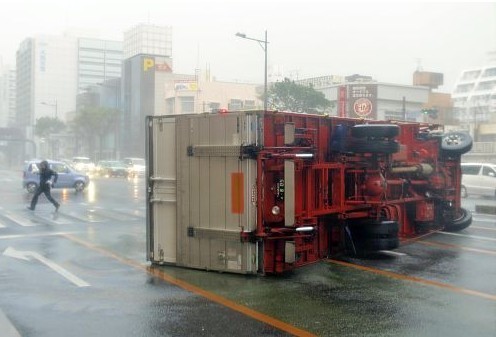 Những chiếc xe tải hạng nặng đang chạy trên đường bị bão lớn quật ngã