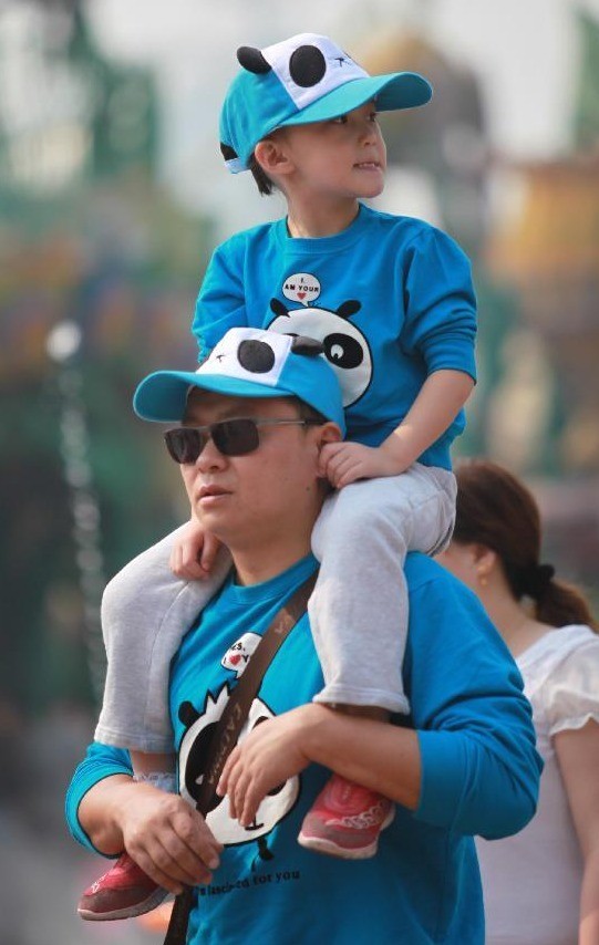 Một ông bố đưa con mình đi chơi tại Happy Valley, Bắc Kinh.