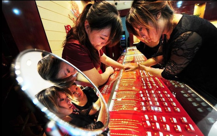 Một khách hàng lựa chọn đồ trang sức vàng tại một cửa hàng ở Yên Đài, tỉnh Sơn Đông, phía đông Trung Quốc.