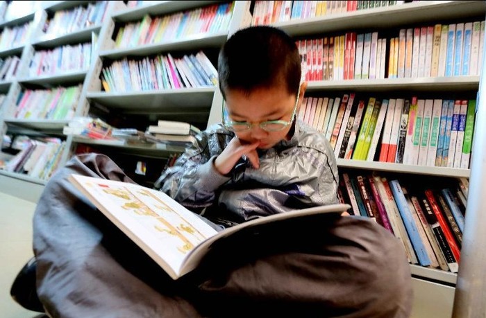 Một cậu bé đọc sách tại một hiệu sách ở tỉnh Giang Tây