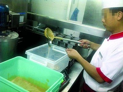Nhân viên nhà hàng Haidibao tại Thành Đô đang lấy bột nhão trong hộp màu xanh để pha chế nước lẩu.
