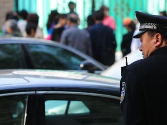 Cảnh sát Trung Quốc túc trực trước cổng nhà trẻ.