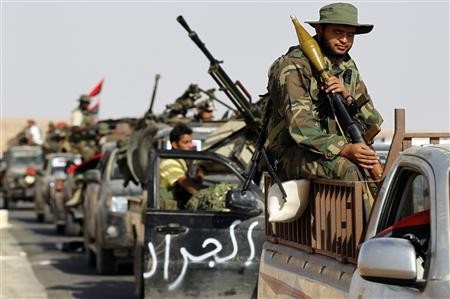 Cảnh các tay súng NTC tiến tới thành phố Bani Walid trong cuộc tấn công nhằm vào 3 thành trì cuối cùng của Đại tá Gaddafi ngày 16/9.