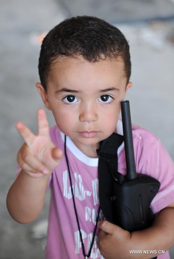 Một em bé ôm khẩu súng trường bên trong tòa nhà House of Shame, ở Bab Al-azizia