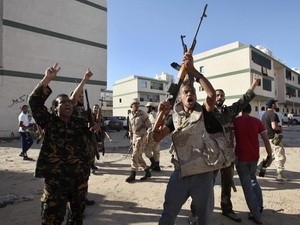 Các tay súng chống đối bắn phá trên các con phố ở Abu Salim, Tripoli hôm 14/10. Ảnh Reuters