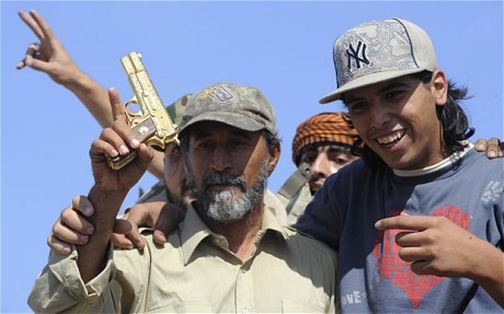 Mohammed el-Bibi (phải) và khẩu súng vàng được cho là Đại tá Gaddafi đã sử dụng trước khi bị bắt