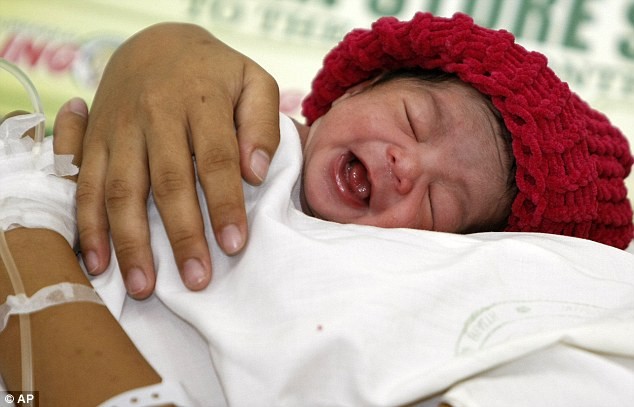 Cô bé Danica May Camacho chào đời vào lúc 23h58 ngày 30/10 tại bệnh viện Jose Fabella, thủ đô Manila, Philippines - quốc gia đứng vị trí thứ 12 trong bảng xếp hạng các nước đông dân nhất thế giới. Ảnh: bé Danica và mẹ tại bệnh viện sau khi sinh.