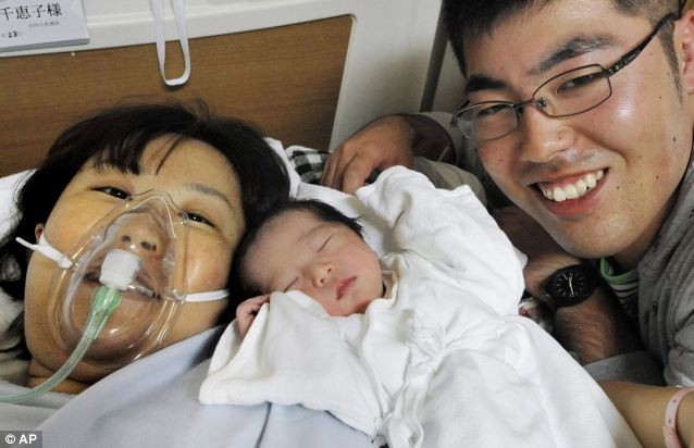 Chieko Takeda, 30 tuổi, và chồng Kei, 27 tuổi, cùng cô con gái mới sinh ở bệnh viện Sendai, Miyagi, Nhật Bản
