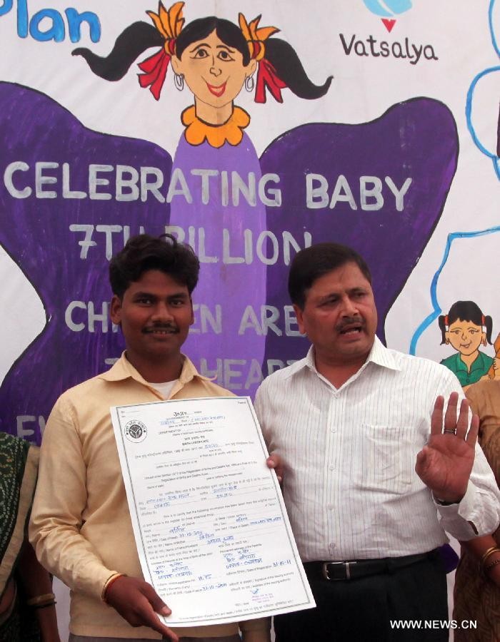 Nhân viên tại Trung tâm Y tế địa phương trao giấy chứng nhận công dân thứ 7 tỷ cho cha bé Nargis