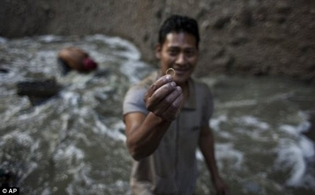 Một "thợ mỏ" tìm thấy chiếc nhẫn vàng sau một hồi tìm kiếm bên dưới dòng sông nước thải