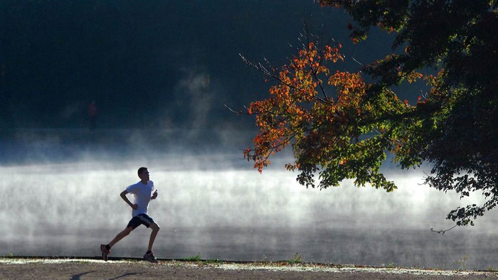 Sương mù bốc lên trên mặt hồ nằm cạnh con đường nơi một người đàn ông chạy thể dục buổi sáng vừa chạy qua ở công viên McAlpine Creek, Charlotte.