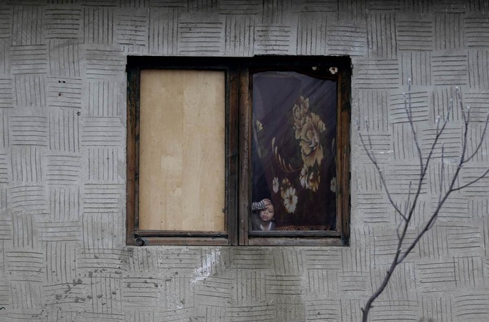 Một bé gái người Roma nhìn qua cửa sổ trong ngôi nhà tại Inke, Hungary hôm 25/11. Những đứa trẻ buộc phải ở nhà vì trường của chúng bị cắt dịch vụ cung cấp khí đốt sưởi ấm do không thể thanh toán các hóa đơn tồn đọng.