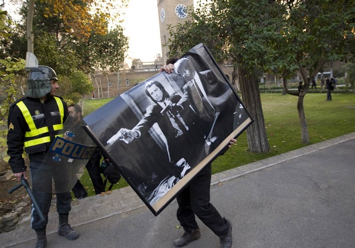 Một người biểu tình mang theo tấm áp phích rời Đại sứ quán Anh tại Tehran, Iran hôm 29/11.