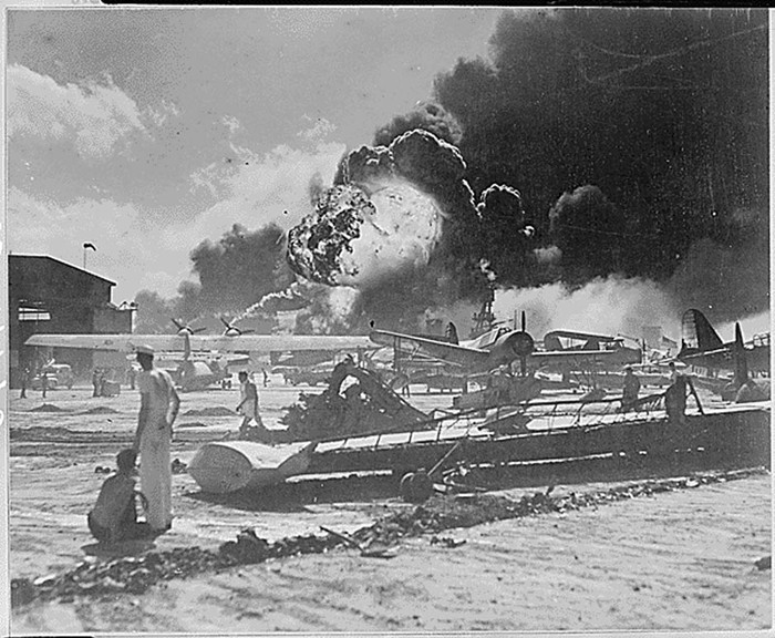 Các binh sĩ Hải quân Mỹ đứng gần đống đổ nát của những chiếc máy bay trong cuộc đột kích trên không của Đế quốc Nhật Bản