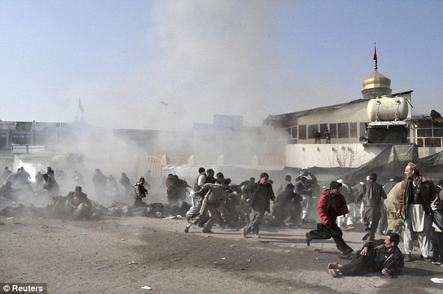 Những người sống sót chạy tới giúp đỡ những người bị thương vài giây sau khi quả bom phát nổ trước cửa nhà thờ Hồi giáo Fazl Abul ở Kabul hôm 6/12
