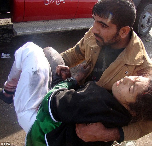 Một người đàn ông chăm sóc cho một phụ nữ bị thương sau vụ đánh bom tự sát.