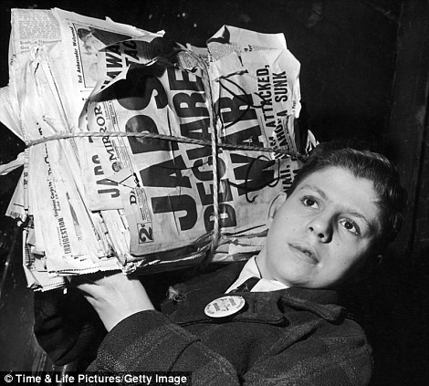 Một cậu bé ôm chồng báo với tờ báo ngoài cùng có tựa đề "Nhật Bản khiêu chiến".
