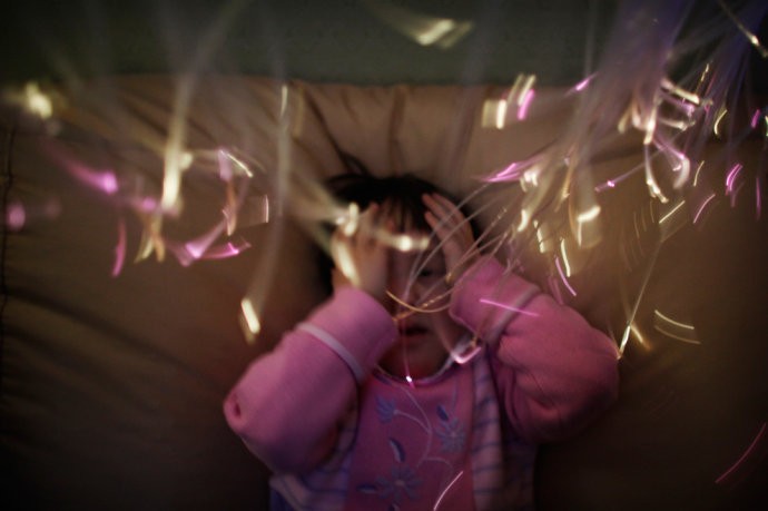 Valeria Zholdin - một nạn nhân nhiễm phóng xạ đang ngắm những ánh sáng quang học phát ra từ một dụng cụ bằng nhựa ngày 15/1/2009. Chiếc đèn được dùng để kiểm soát cảm xúc của cô bé.
